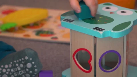 Child Trying Different Ways To Put Block In Shape Sorter Stock Footage 329325053