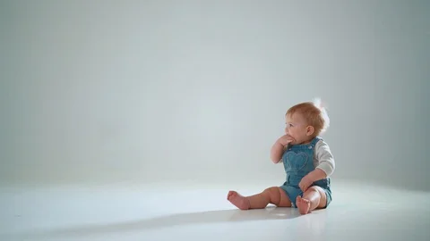 The child is trying to get off his knees on two legs but falls. slow motion 스톡 동영상 128246746