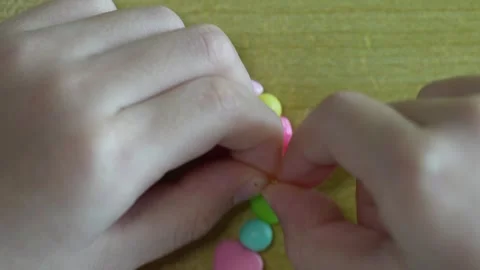 Child tying elastic bracelet knot in last step Stock Footage 334426421
