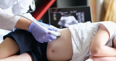 Child undergoing ultrasound to determine position of kidney stones before Stock Footage 261690833