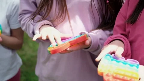 Child unrecognizable hands play trendy silicon fidgeting game sensory toy pop Stock Footage 156479747