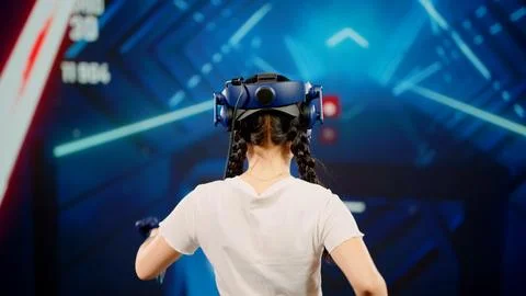 The child use tracking controllers in her hands, moves actively immersing Stock Photos