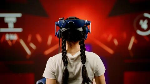 The child use tracking controllers in her hands, moves actively immersing Stock Photos