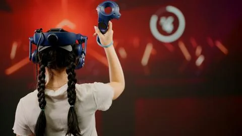 The child use tracking controllers in her hands, moves actively immersing Stock Photos