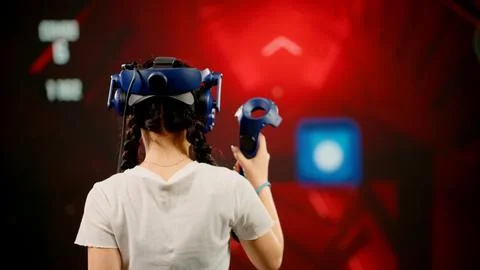 The child use tracking controllers in her hands, moves actively immersing Stock Photos