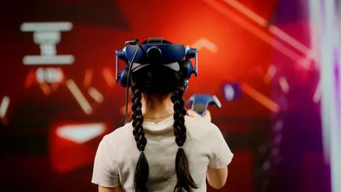 The child use tracking controllers in her hands, moves actively immersing Stock Photos