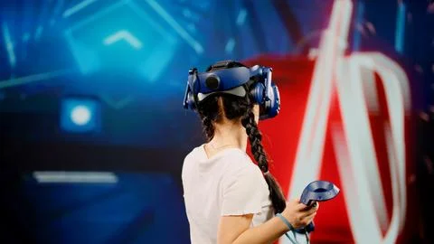 The child use tracking controllers in her hands, moves actively immersing Stock Photos