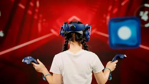 The child use tracking controllers in her hands, moves actively immersing Stock Photos