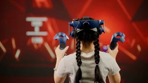 The child use tracking controllers in her hands, moves actively immersing Stock Photos
