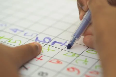 Child uses colored markers for math activity Stock Photos