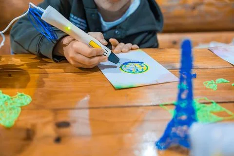 Child using 3D pen to create colorful drawings and objects. Selective focus Stock Photos