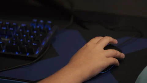 Child using computer mouse with illuminated gaming keyboard Stock Footage 282572109
