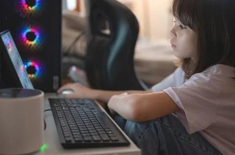 Child using computer in a room during the afternoon Stock Photos