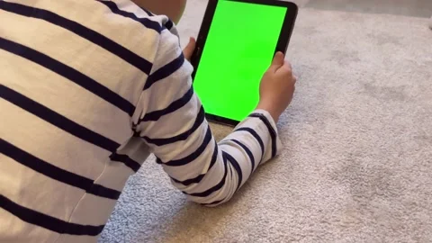Child using a digital tablet PC with green screen, back view Stock Footage 173504151