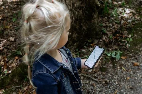 Child using mobile map app to track hike on trail Stock Photos