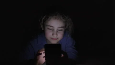 Child Using Mobile Phone Evening at Home. Teen Girl Watching Online Video S.. Stock Footage 329447097