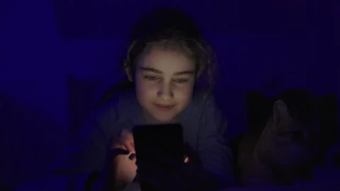 Child Using Mobile Phone Evening at Home. Teen Girl Watching Online Video S.. Stock Footage 329447720