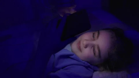 Child Using Mobile Phone Evening at Home. Teen Girl Watching Online Video S.. Stock Footage 329448822