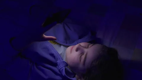 Child Using Mobile Phone Evening at Home. Teen Girl Watching Online Video S.. Stock Footage 345744249