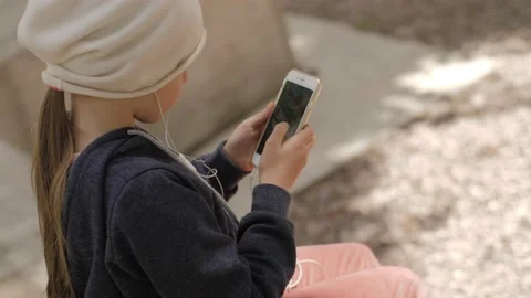 Child is using mobile phone. Kid is looking at screen of devices. Stock-Footage 131772662