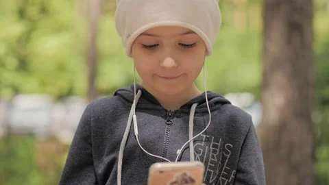 Child is using mobile phone. Kid is looking at screen of devices. Stock-Footage 131772822