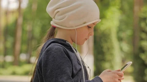 Child is using mobile phone. Kid is looking at screen of devices. Stock-Footage 132998250
