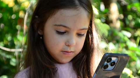 Child is using mobile phone. Kid is looking at screen of devices Video stock 282860849