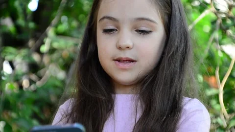 Child is using mobile phone. Kid is looking at screen of devices Video stock 282860893