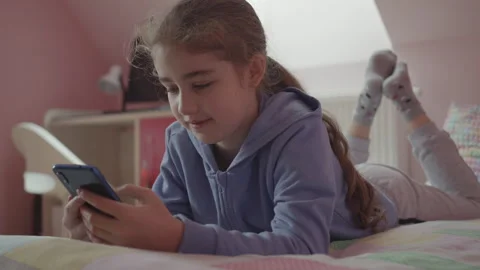 Child Using Mobile Phone Writes Messages in Chat at Home. Teen Girl Watching Stock Footage 274694824