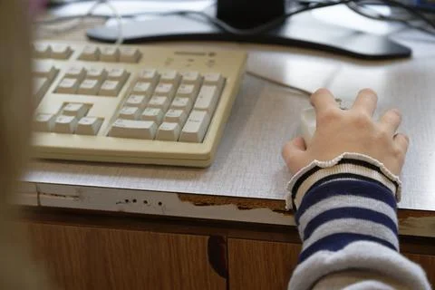 Child Using Mouse at Worn Wooden Desk Stock Photos