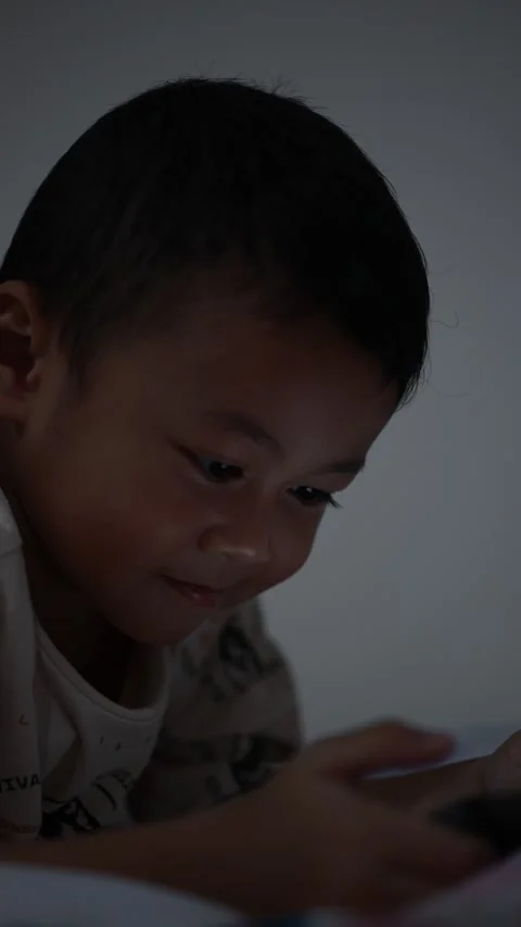 Child using phone on sofa at home 스톡 동영상 333888344