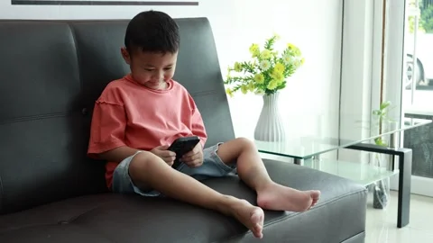 Child using phone on sofa at home Stock-Footage 333888662