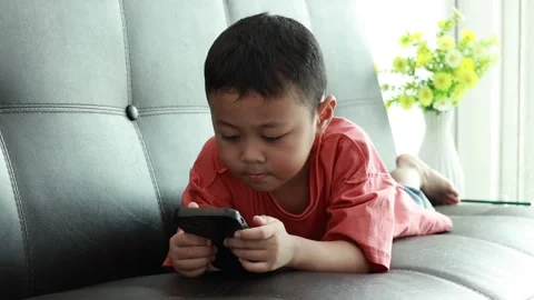 Child using phone on sofa at home Stock Footage 333888694