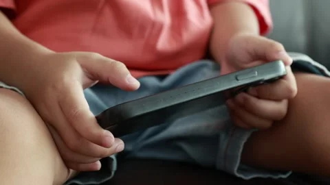 Child using phone on sofa at home Stock Footage 333888850