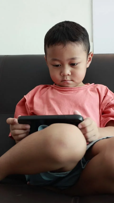Child using phone on sofa at home Stock Footage 333888987