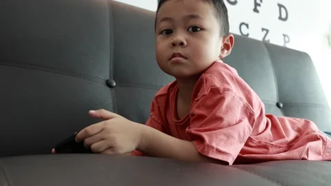 Child using phone on sofa at home Stock Footage 333889011
