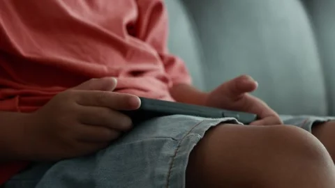 Child using phone on sofa at home Stock Footage 333889030