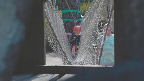 Child using a rope bridge in an adventure park in the sun Stock Footage 88903714