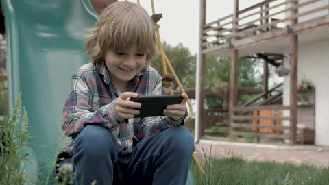 Child using smart phone online on the playground Stock Footage 169222298