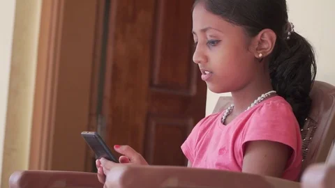 Child Using Smartphone Sending Messages to Friends Girl Playing Games smiling Video stock 128502654