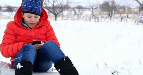 Child using smartphone in winter park 3 스톡 동영상 85303102