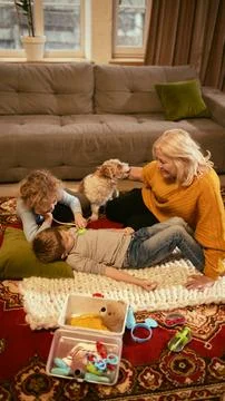 Child using stethoscope on sibling during role-play, focusing on development of Stock Photos