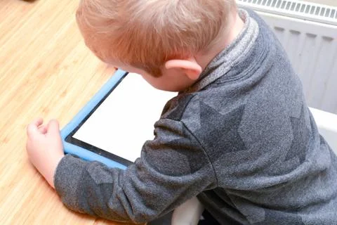 Child using a tablet device to learn and play games, model is young boy Stock Photos