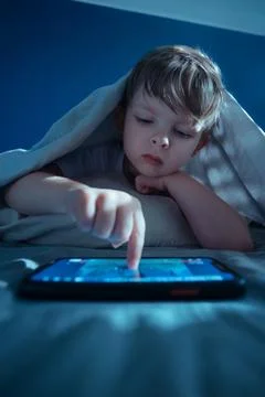 Child using tablet or smartphone at night 스톡 사진