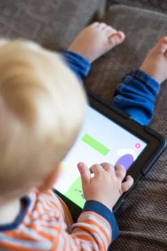 Child using a touch screen tablet to play learning game Stock Photos