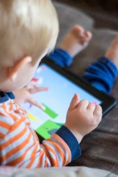 Child using a touch screen tablet to play learning game Stock Photos
