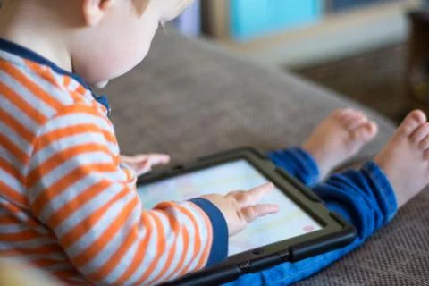 Child using a touch screen tablet to play learning game Stock Photos
