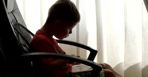 Child Using Touchpad While Playing Video Games Sitting in the Office Chair 動画素材 64827944