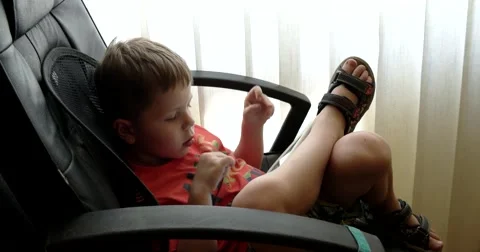 Child Using Touchpad While Playing Video Games Sitting in the Office Chair Stockbeeldmateriaal 64857253