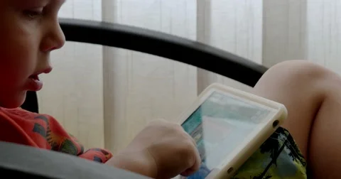 Child Using Touchpad While Playing Video Games Sitting in the Office Chair Vídeo Stock 64857343
